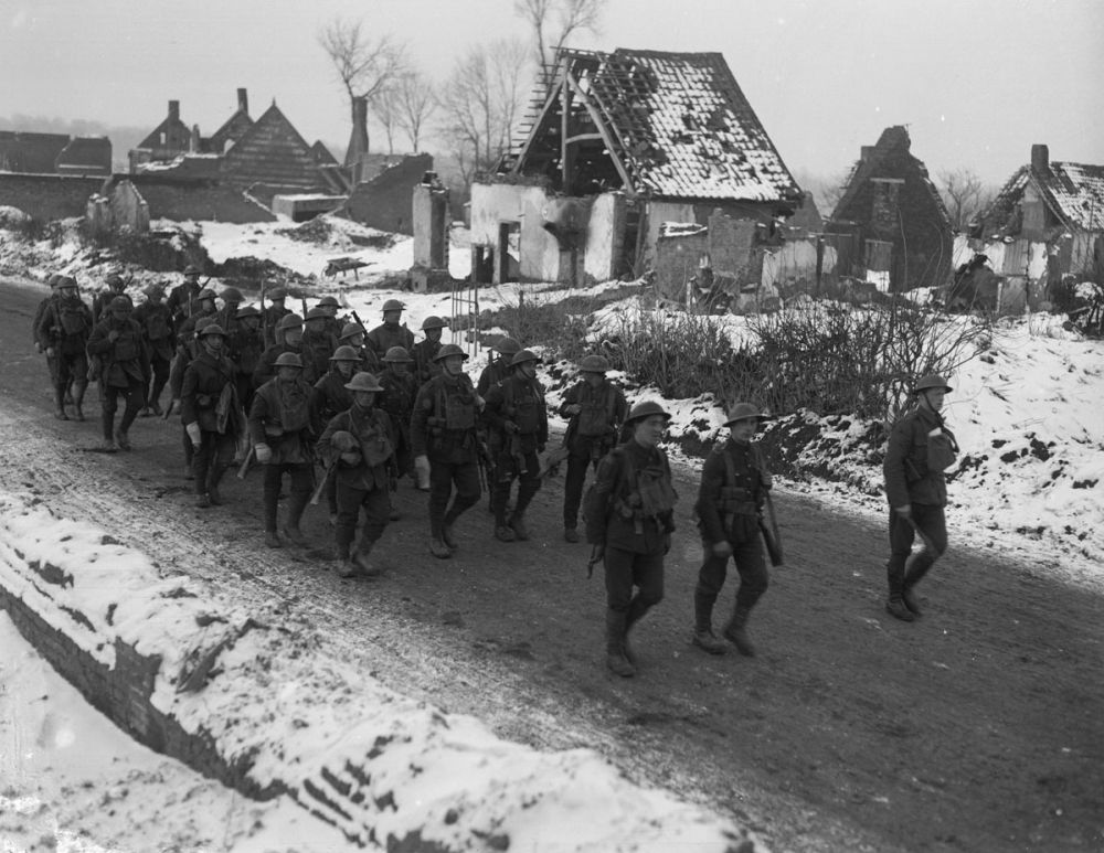 British soldiers march past the ruins of the village of Metz-en-Couture, 2 January 1918.
